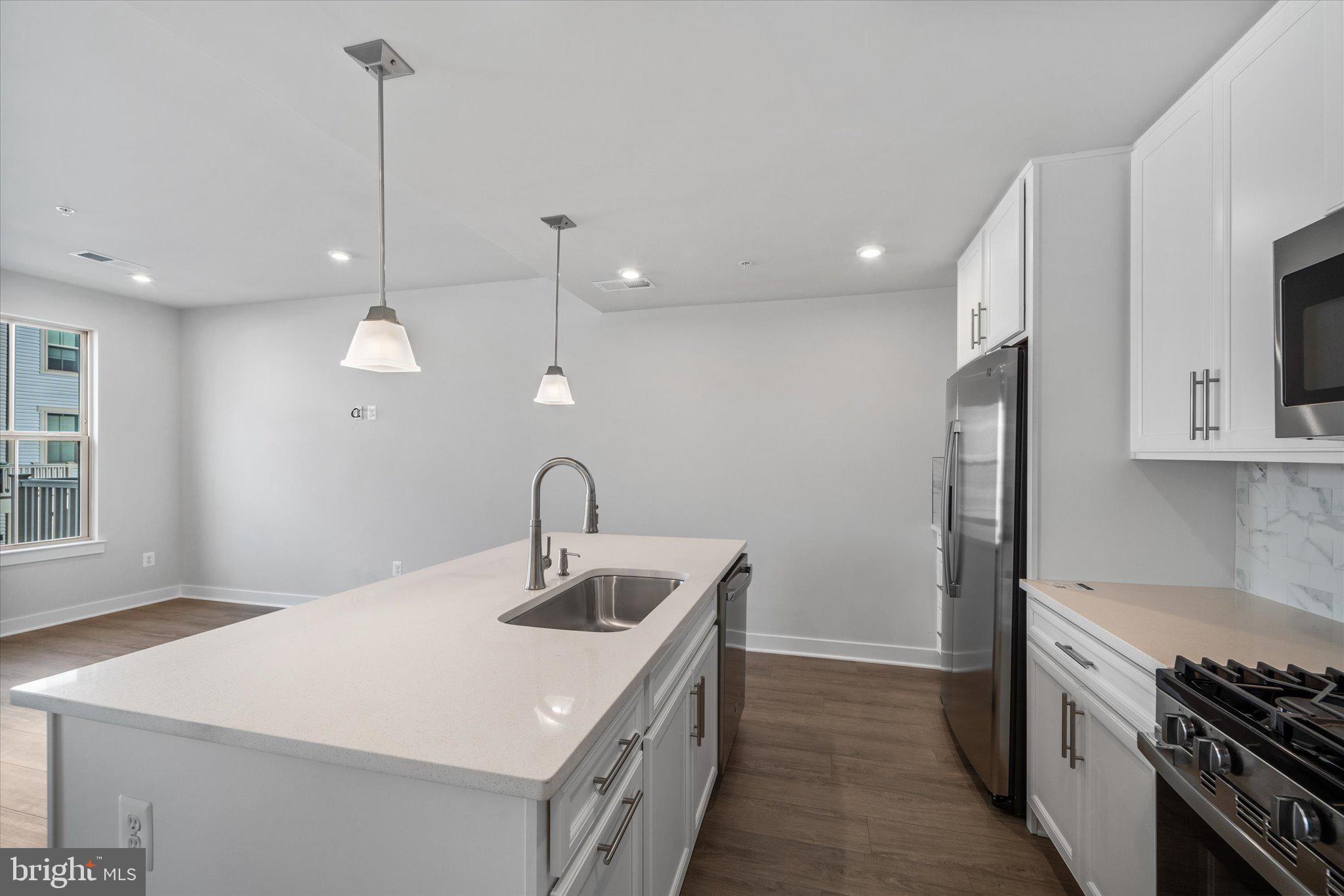 42530 Invergordon Terrace Sterling, VA 20166 - Photo 9 of 39 a kitchen with kitchen island a sink stainless steel appliances and window