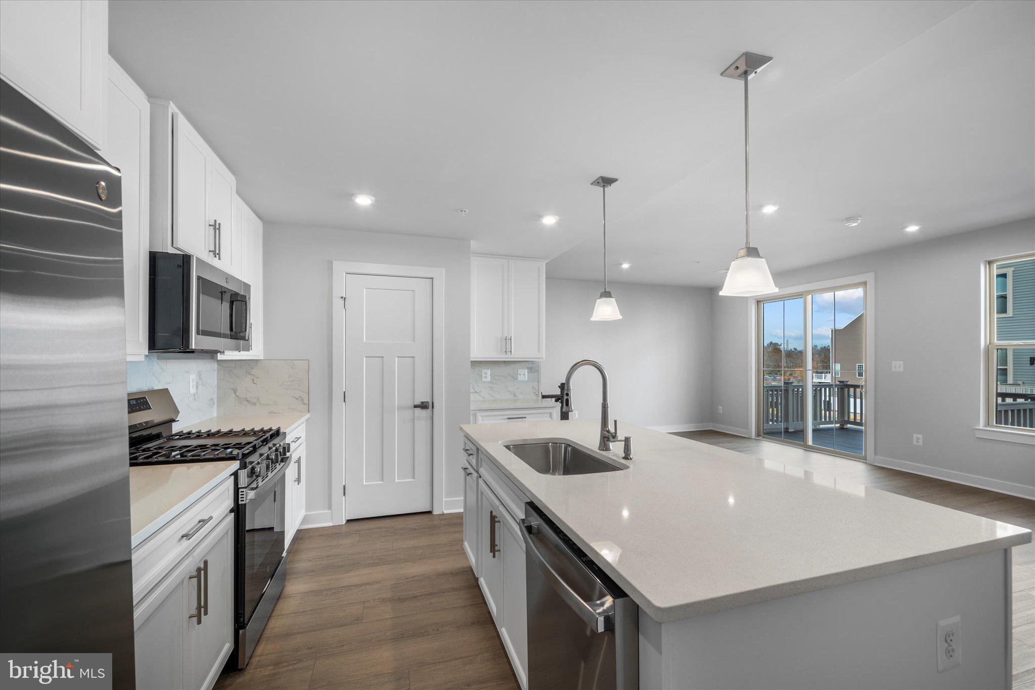 42530 Invergordon Terrace Sterling, VA 20166 - Photo 10 of 39 a kitchen with stainless steel appliances granite countertop a sink a stove and a refrigerator