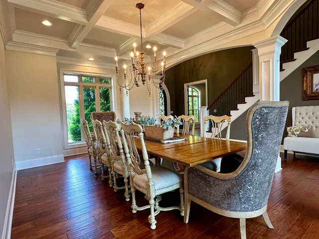 a kitchen with stainless steel appliances kitchen island granite countertop a stove a sink dishwasher and a dining table with wooden floor