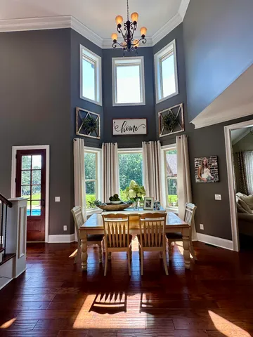 a view of a dining room with furniture wooden floor and chandelier