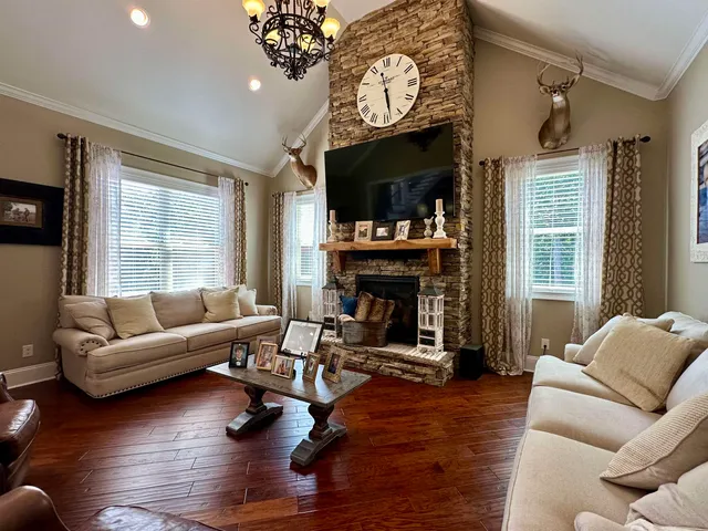a view of a dining room with furniture a chandelier and wooden floor