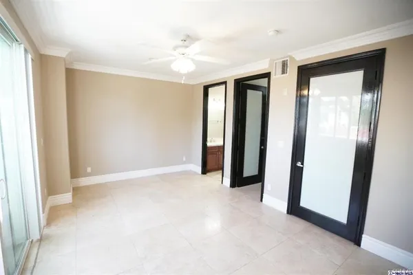 a view of an empty room with closet and a window