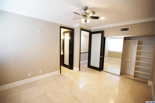 an empty room with closet and windows