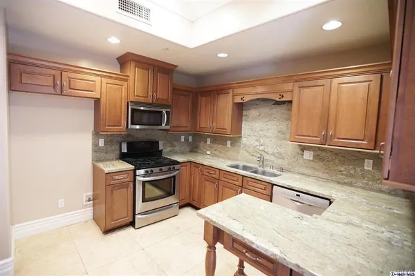 a kitchen with granite countertop a stove top oven sink and cabinets
