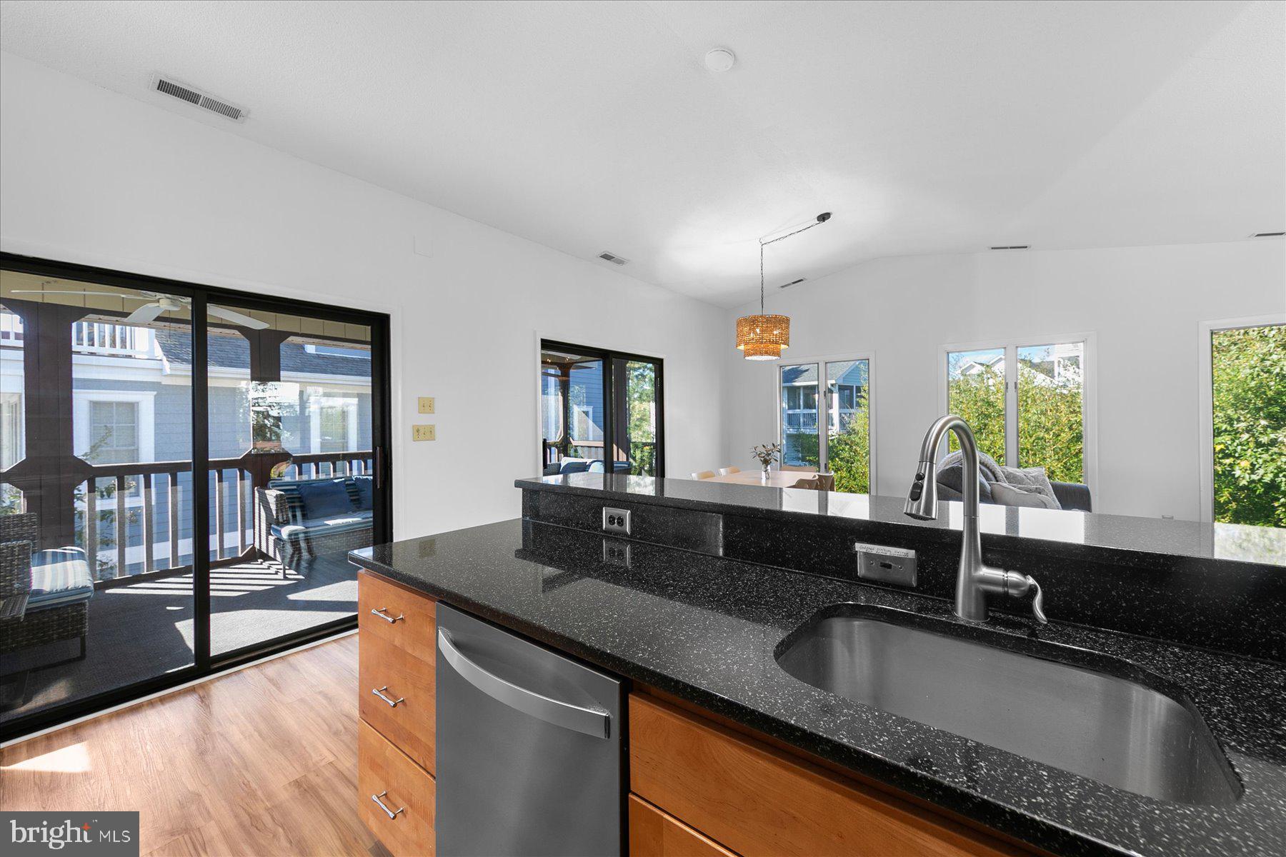 39692 Kittiwake Road Bethany Beach, DE 19930 - Photo 11 of 32 a kitchen with granite countertop a sink and a wooden floor