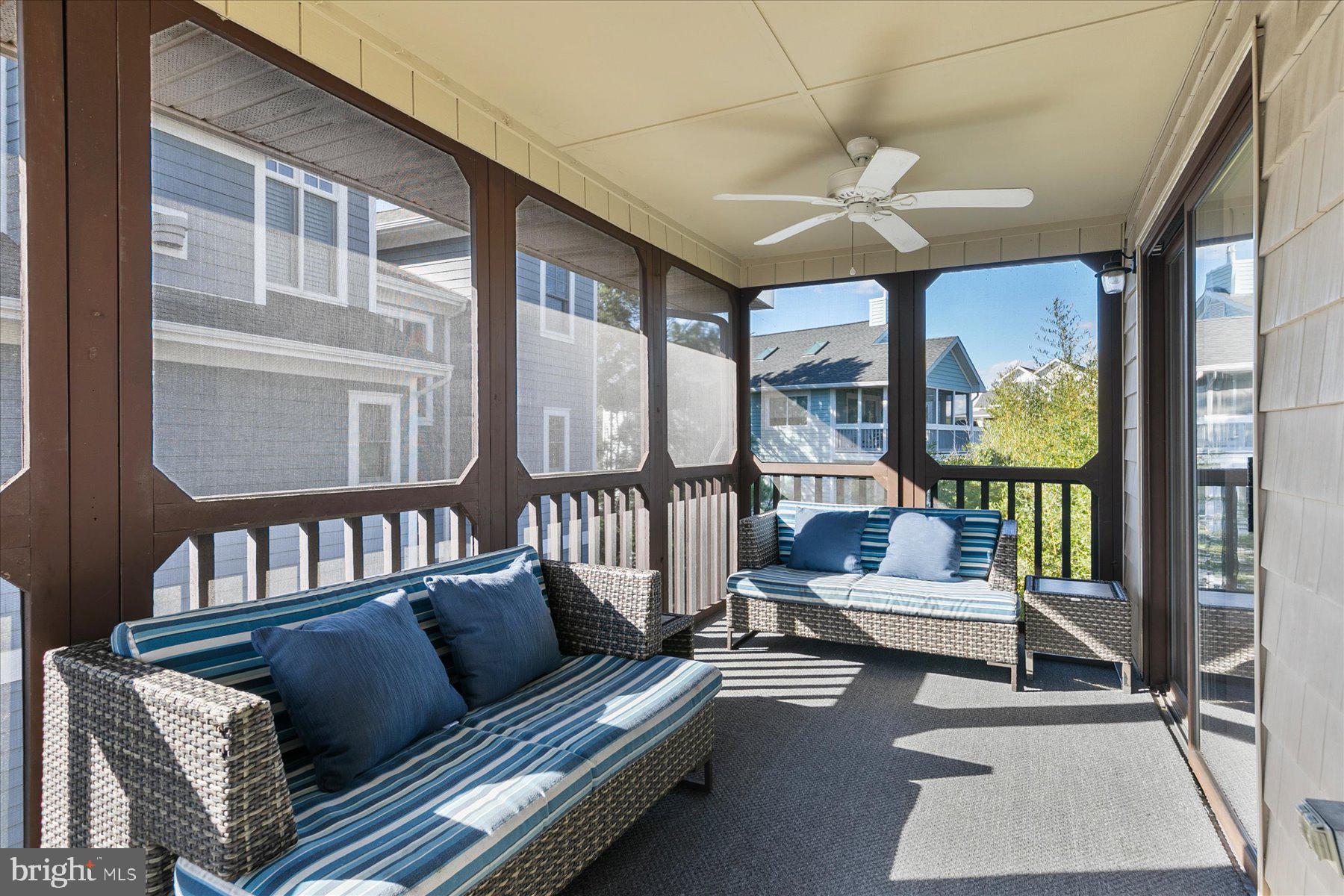 39692 Kittiwake Road Bethany Beach, DE 19930 - Photo 15 of 32 a living room with furniture a ceiling fan and a large window