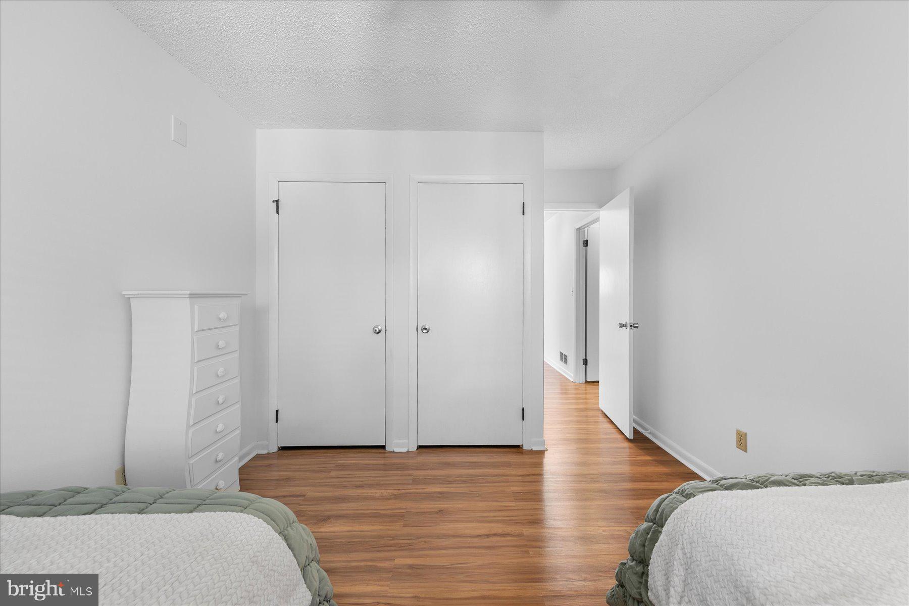 39692 Kittiwake Road Bethany Beach, DE 19930 - Photo 26 of 32 a bedroom with a bed and wooden floor