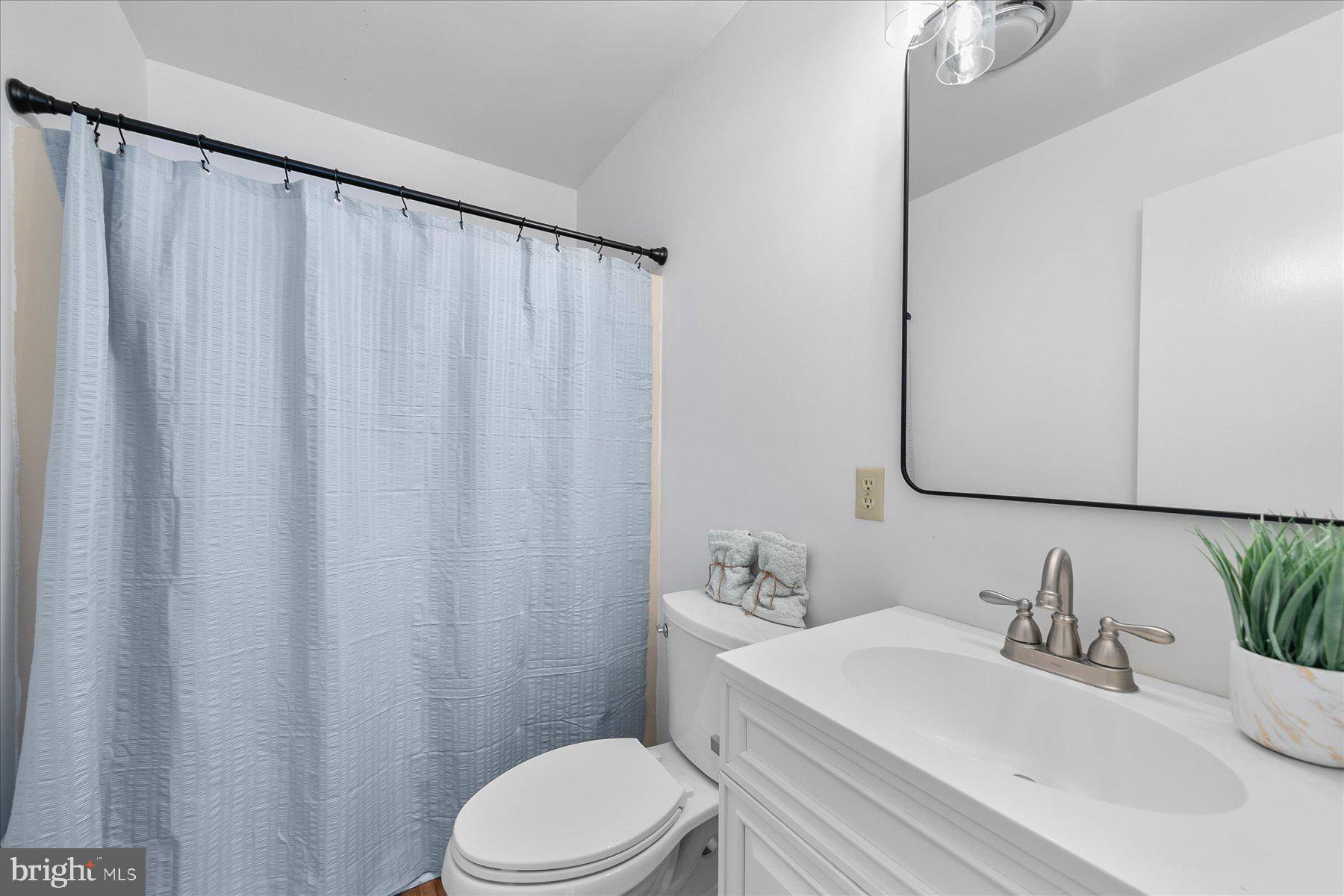 39692 Kittiwake Road Bethany Beach, DE 19930 - Photo 29 of 32 a bathroom with a sink a toilet and shower curtain