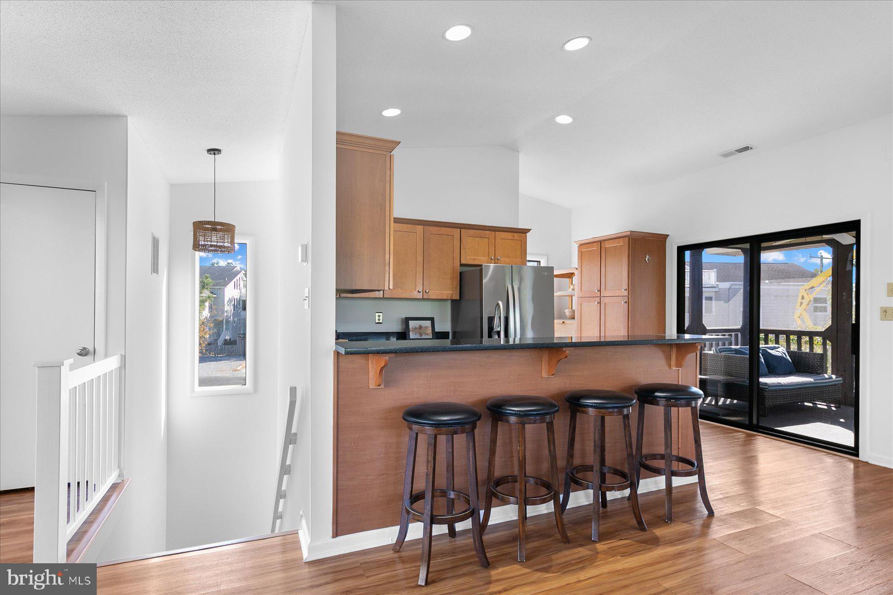39692 Kittiwake Road Bethany Beach, DE 19930 - Photo 8 of 32 a kitchen with stainless steel appliances granite countertop a table chairs refrigerator and sink