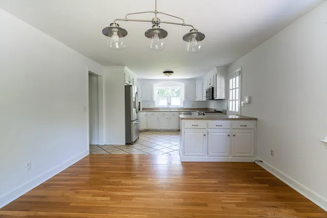 a kitchen with granite countertop white cabinets and stainless steel appliances