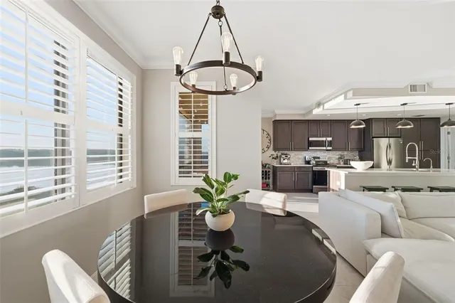 a kitchen with kitchen island a refrigerator a stove a dining table and chairs with wooden floor