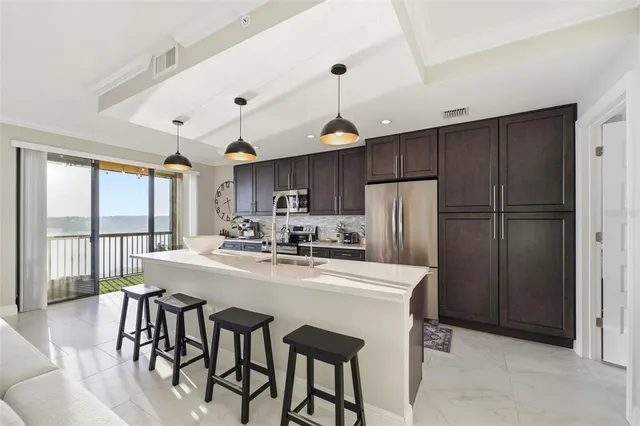 a large kitchen with stainless steel appliances granite countertop a sink a stove and a wooden floors