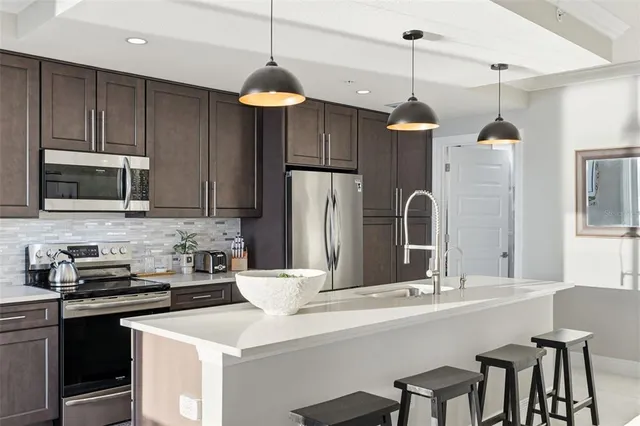 a kitchen with granite countertop a sink a counter space cabinets and stainless steel appliances