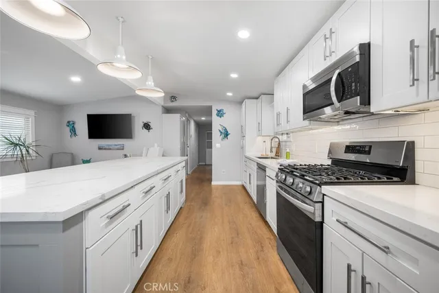 a large kitchen with stainless steel appliances and white cabinets