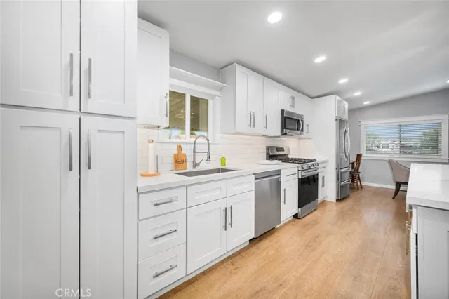 a kitchen with white cabinets and white appliances