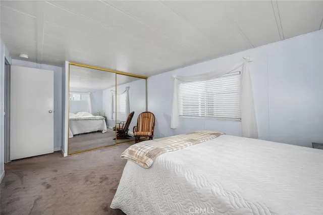 a bedroom with a bed and a large window