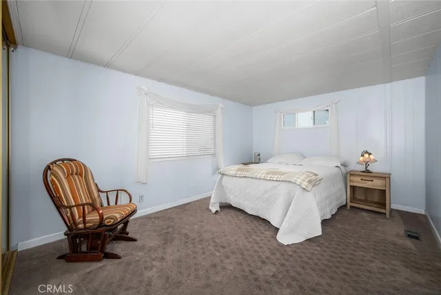 a bedroom with a bed chair and window