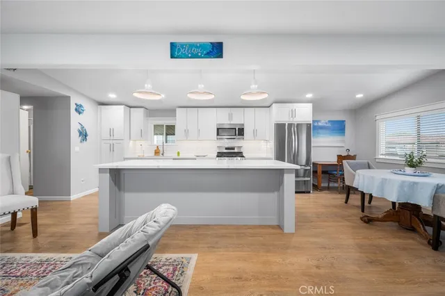 a living room with stainless steel appliances furniture fireplace and a table