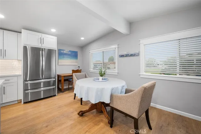 a view of a dining room with furniture a kitchen and chandelier