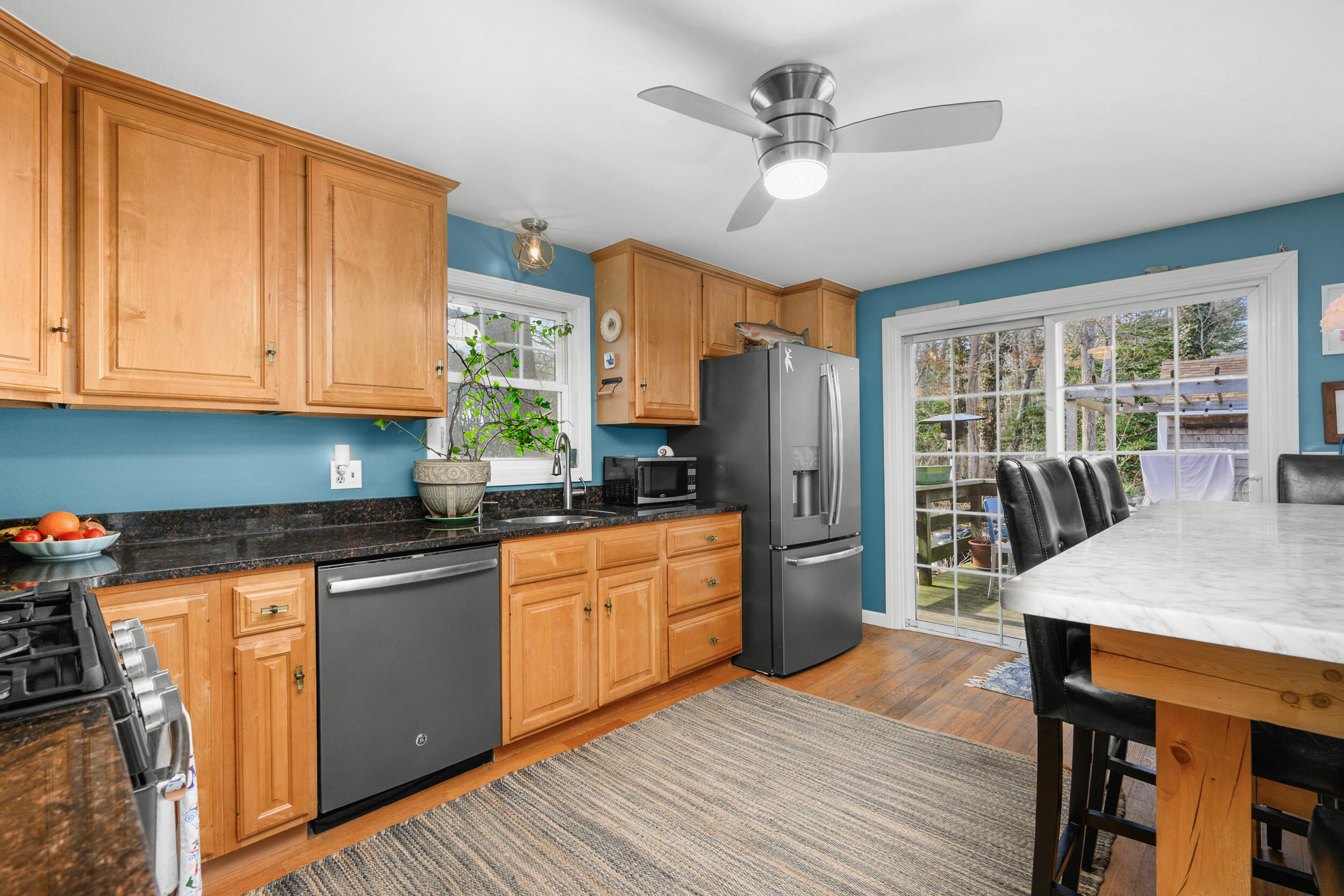 43 Chickadee Lane Centerville, MA 02632 - Photo 12 of 48 a kitchen with stainless steel appliances granite countertop a refrigerator a sink dishwasher a stove and white countertops with wooden floor