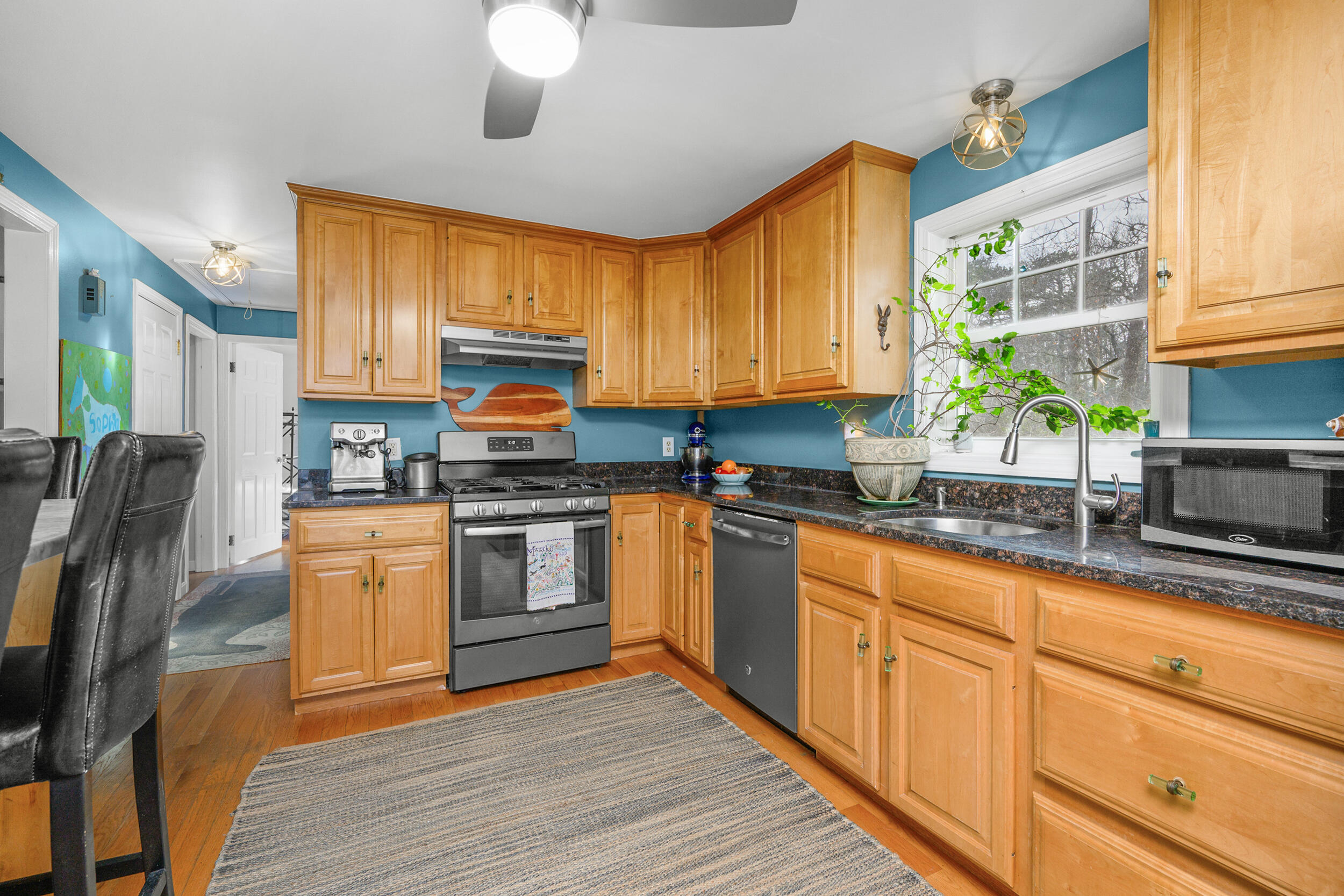 43 Chickadee Lane Centerville, MA 02632 - Photo 15 of 48 a kitchen with granite countertop wooden floors stainless steel appliances and window