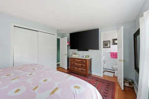 a bedroom with a bed and a flat screen tv in it
