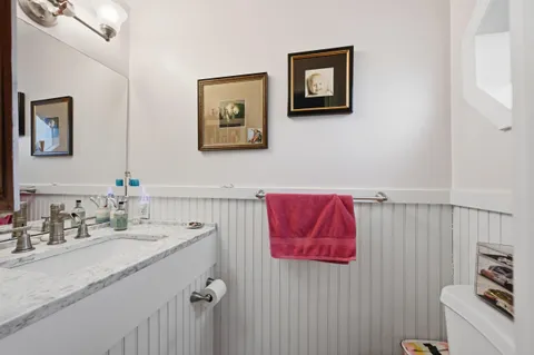 a bathroom with a granite countertop sink vanity and toilet