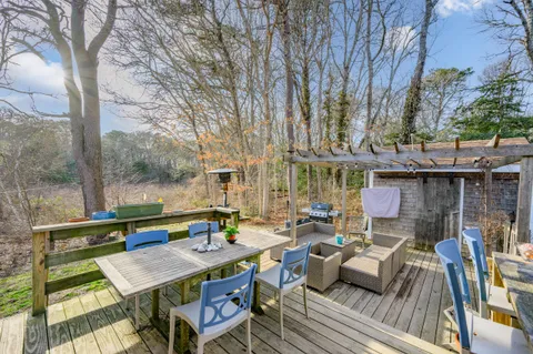 a view of a patio with couches table and chairs and wooden floor