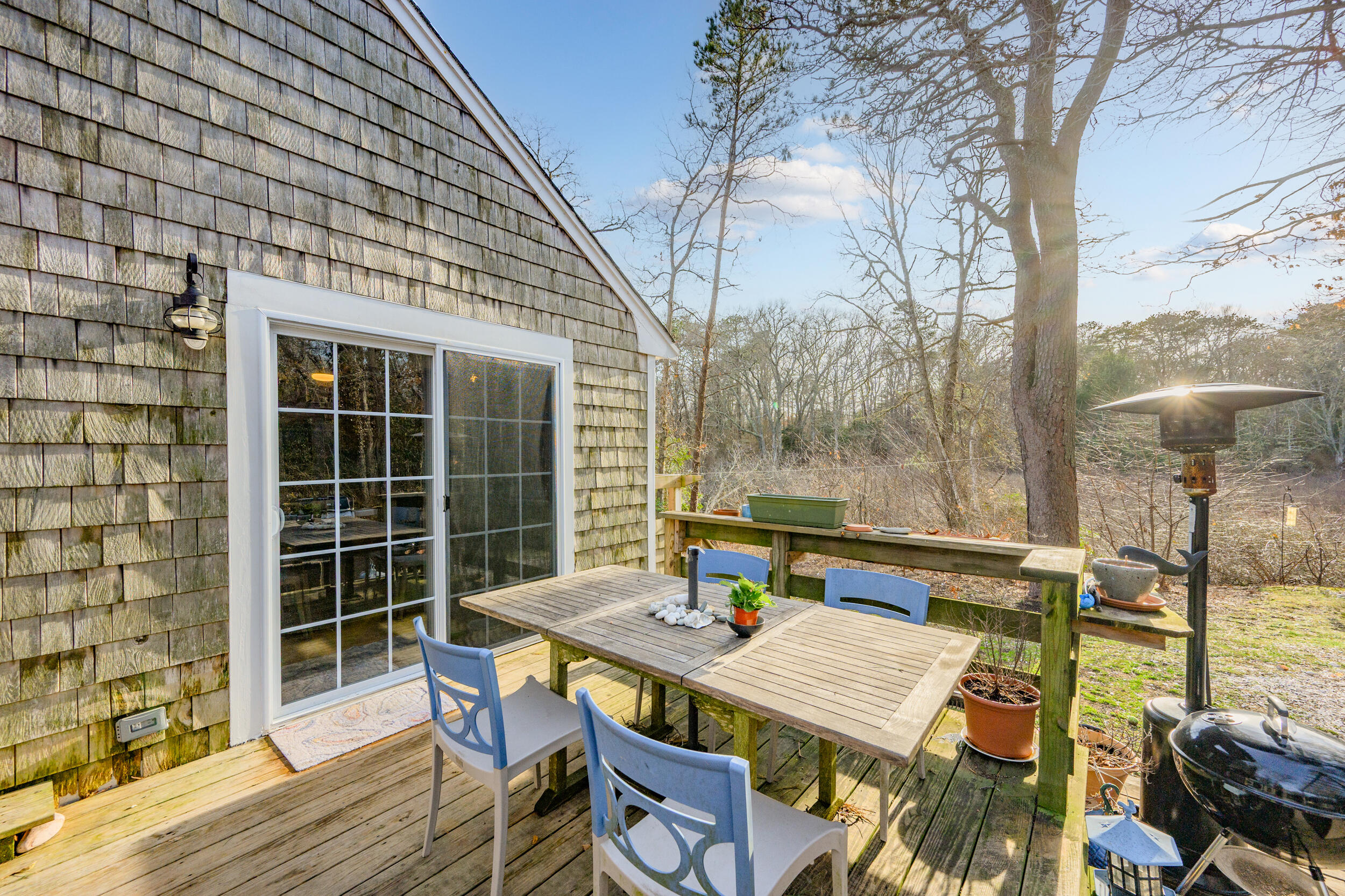 43 Chickadee Lane Centerville, MA 02632 - Photo 28 of 48 a view of a patio with table and chairs with wooden floor and fence