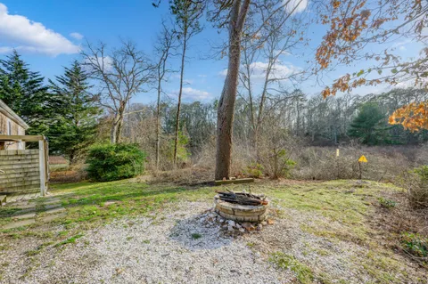 a view of a backyard with a bench and trees