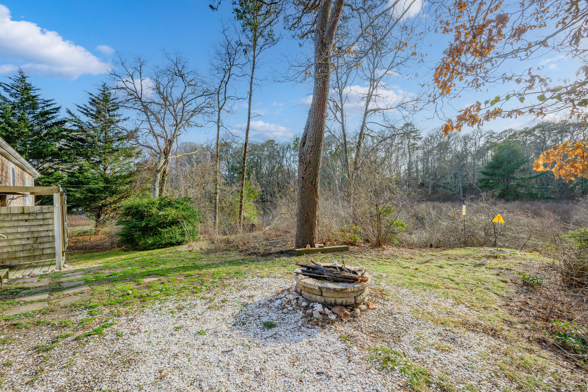 43 Chickadee Lane Centerville, MA 02632 - Photo 30 of 48 a view of a backyard with a bench and trees