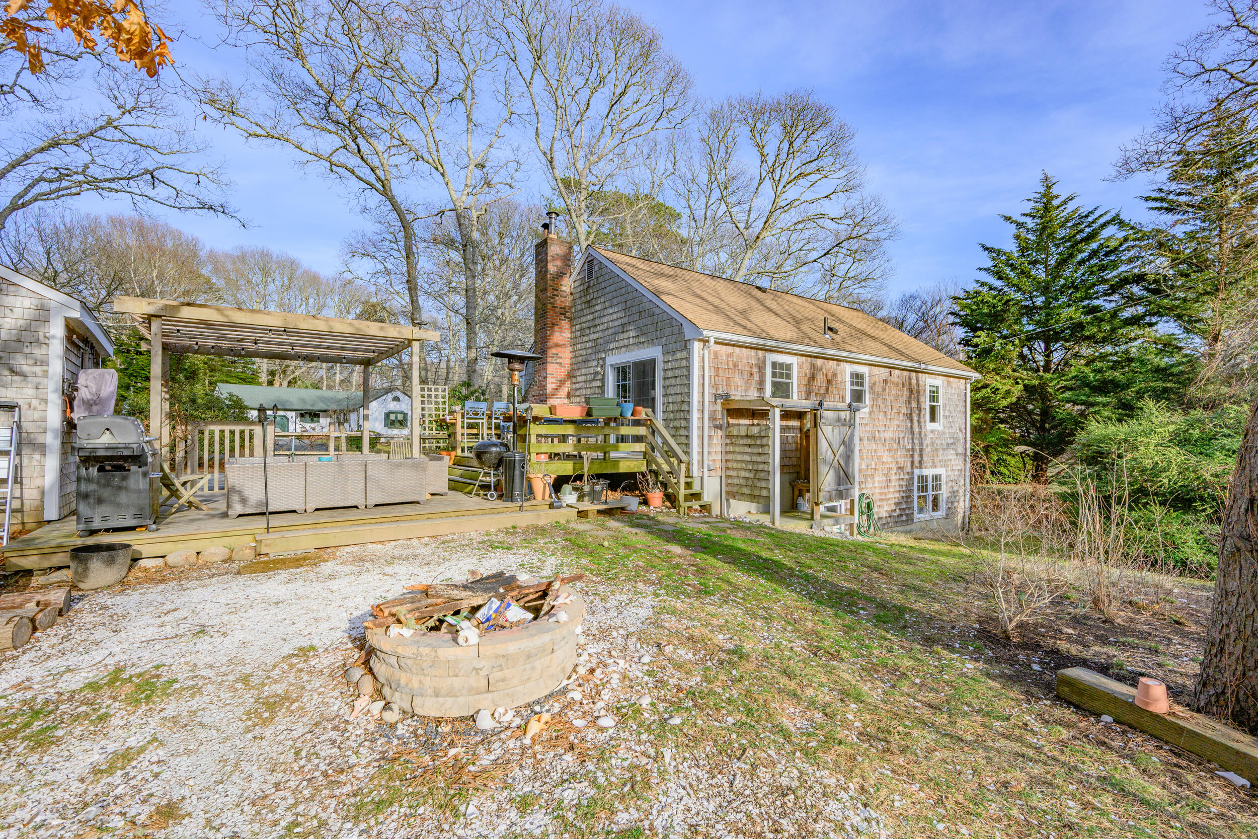 43 Chickadee Lane Centerville, MA 02632 - Photo 33 of 48 a front view of a house with a yard table and chairs