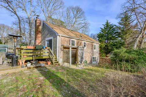 a view of a house with backyard and sitting area