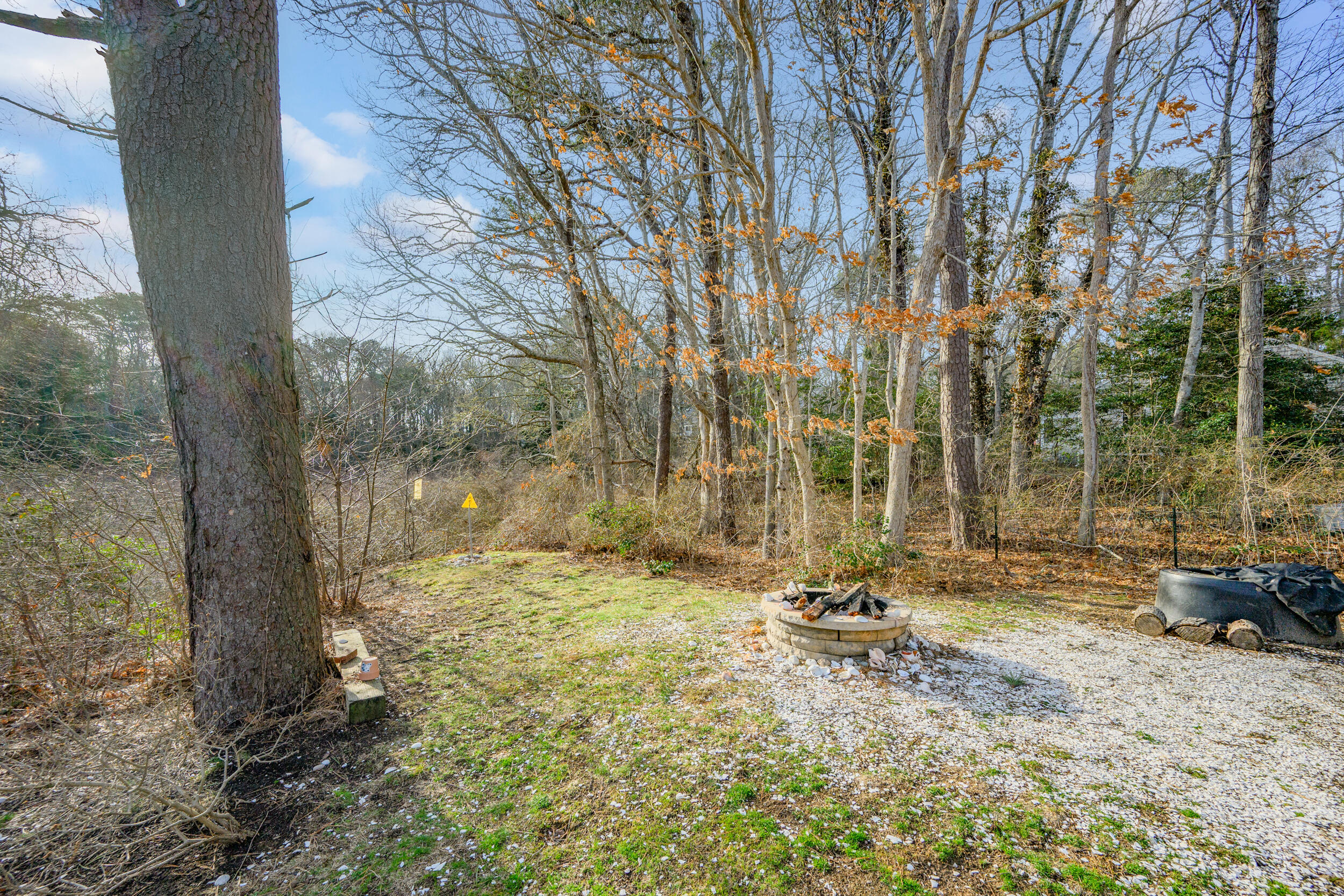 43 Chickadee Lane Centerville, MA 02632 - Photo 37 of 48 a backyard of a house with table and chairs