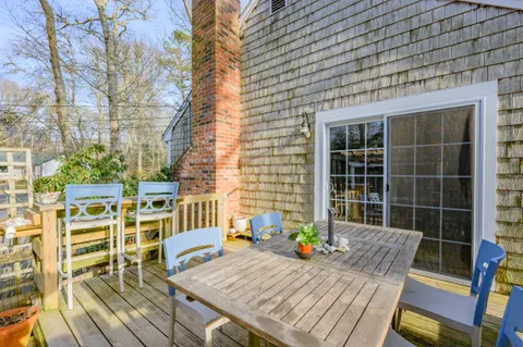 a view of a deck with table and chairs with wooden floor and plants