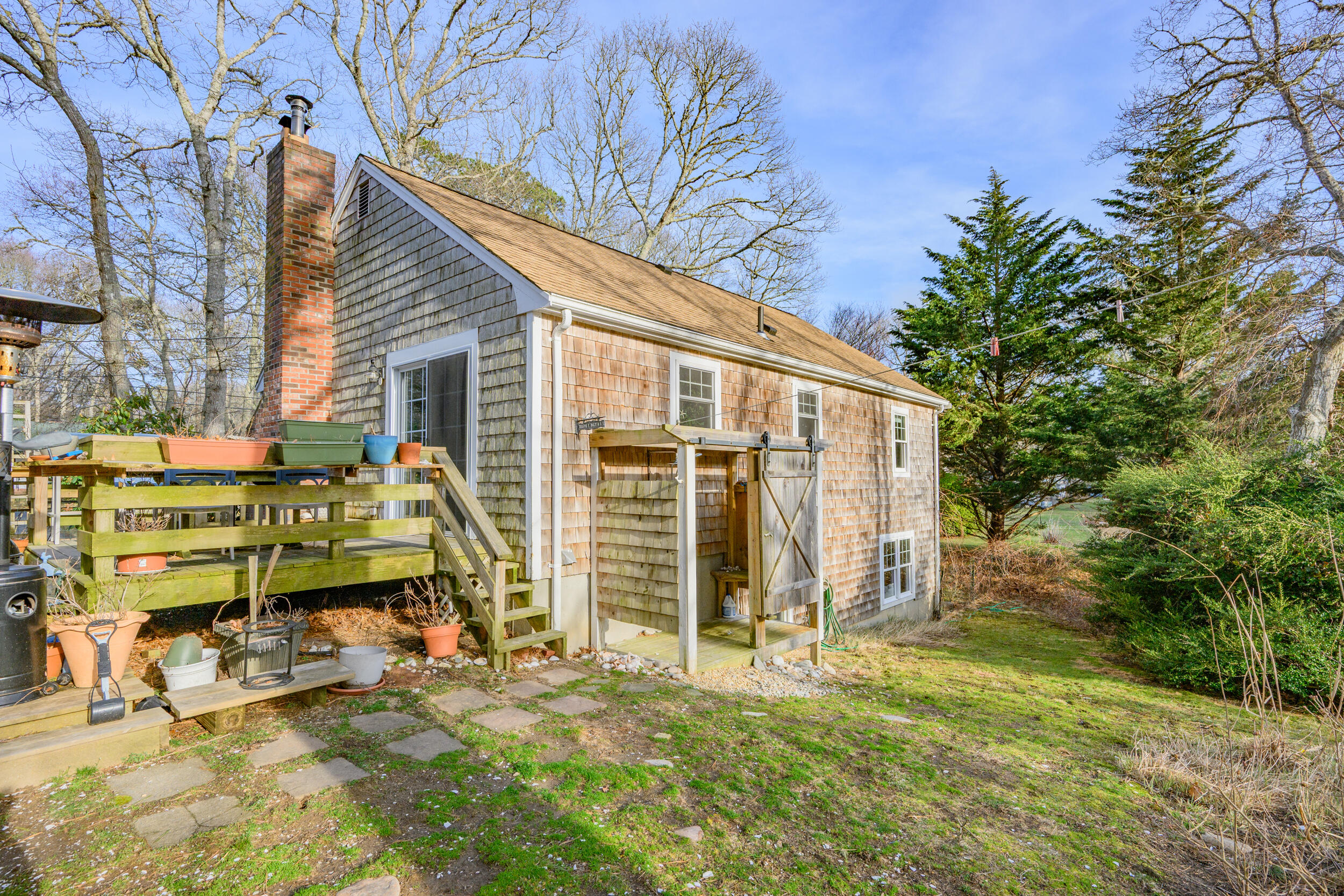 43 Chickadee Lane Centerville, MA 02632 - Photo 39 of 48 a view of backyard with a table and chairs and potted plants