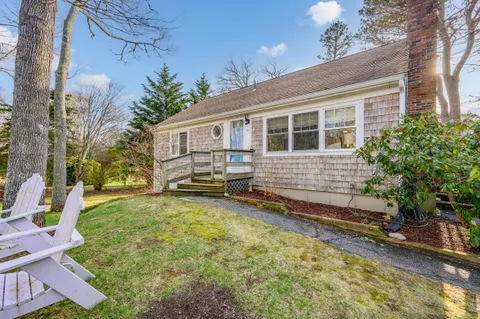 a view of a house with backyard and sitting area