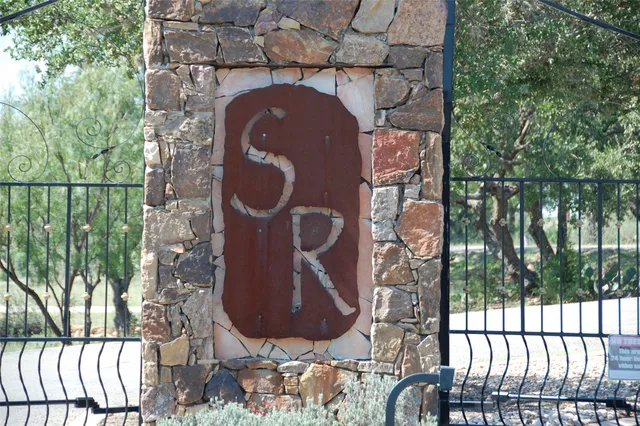 a view of a backyard with table and chairs plants and trees