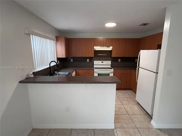 a kitchen with stainless steel appliances granite countertop a refrigerator a stove a sink and a refrigerator