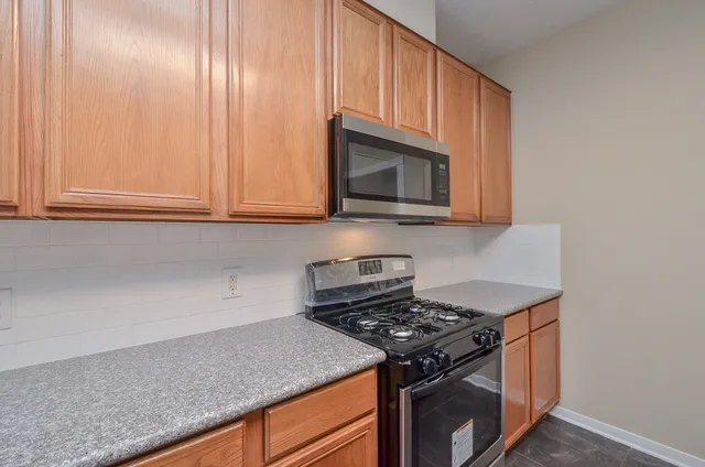 a kitchen with granite countertop cabinets stainless steel appliances and wooden floor