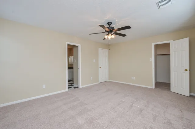 a view of an empty room with a ceiling fan