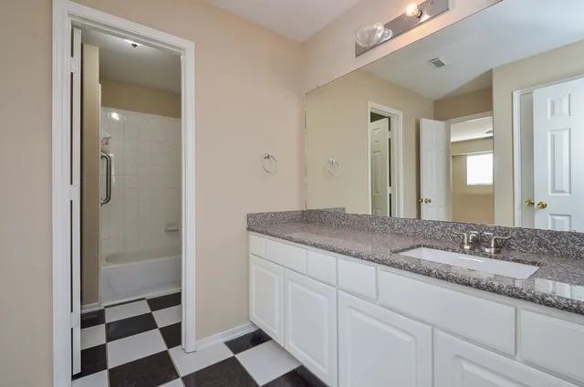 a bathroom with a granite countertop sink and a mirror