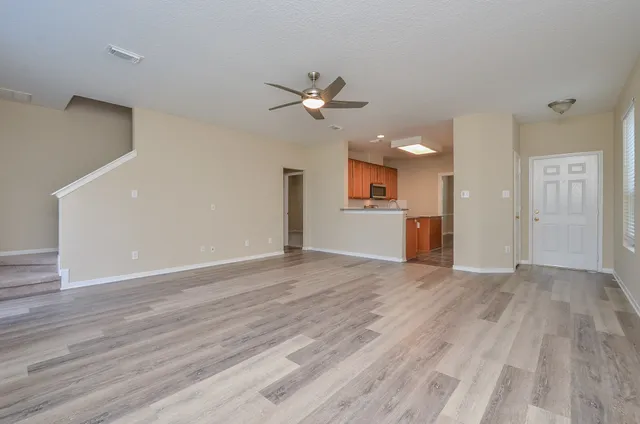 a view of an empty room with a kitchen