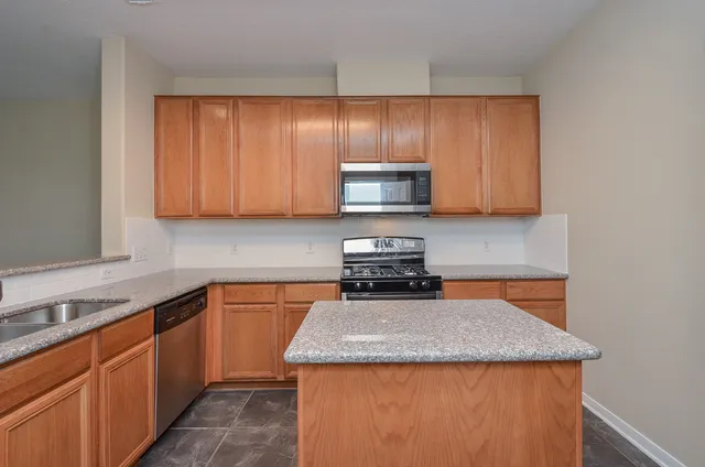 a kitchen with stainless steel appliances granite countertop a sink stove and microwave