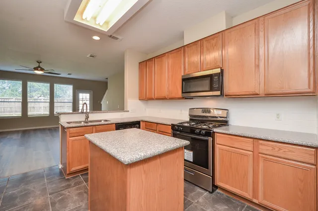 a kitchen with stainless steel appliances granite countertop a sink stove microwave and cabinets