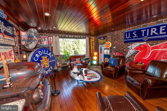 a kitchen with stainless steel appliances kitchen island granite countertop a refrigerator a stove a sink a dining table and chairs with wooden floor