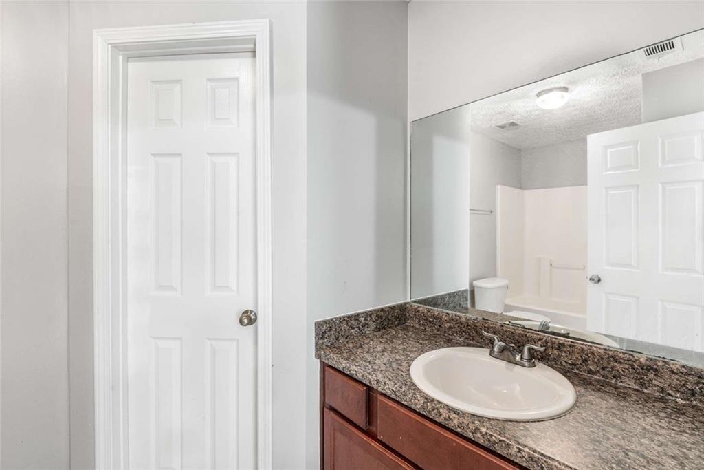 588 Elles Way Griffin, GA 30223 - Photo 25 of 32 a bathroom with a granite countertop sink and a mirror