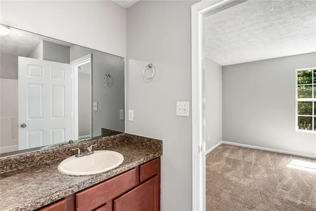 a bathroom with a granite countertop sink and a mirror