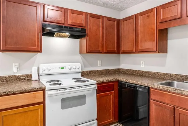 a kitchen with granite countertop cabinets stainless steel appliances and wooden cabinets