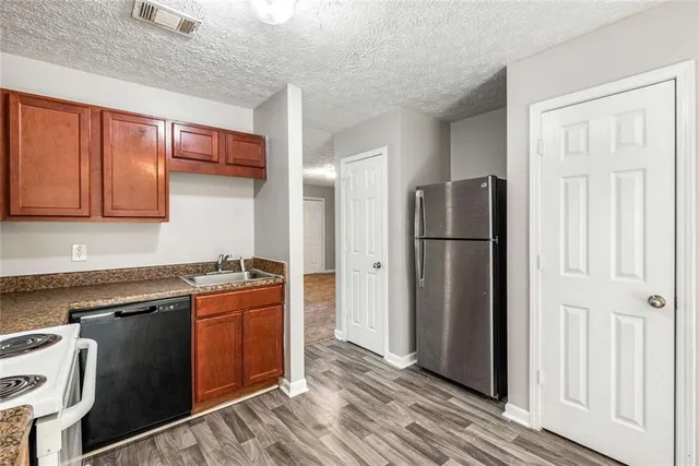 a kitchen with stainless steel appliances granite countertop a refrigerator stove and sink